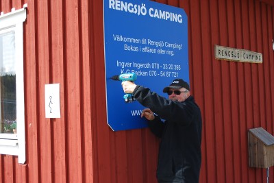 Centrumansvarige Ingvar Ingeroth sätter upp en informationstavla på campingstugan inför säsongstarten.