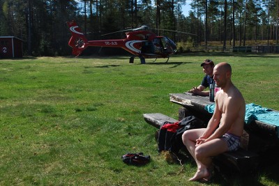 Piloten Tore Schultzberg njöt av det vackra badet och årets premiärdopp vid Skidtjärn. I bakgrunden  helikoptern.